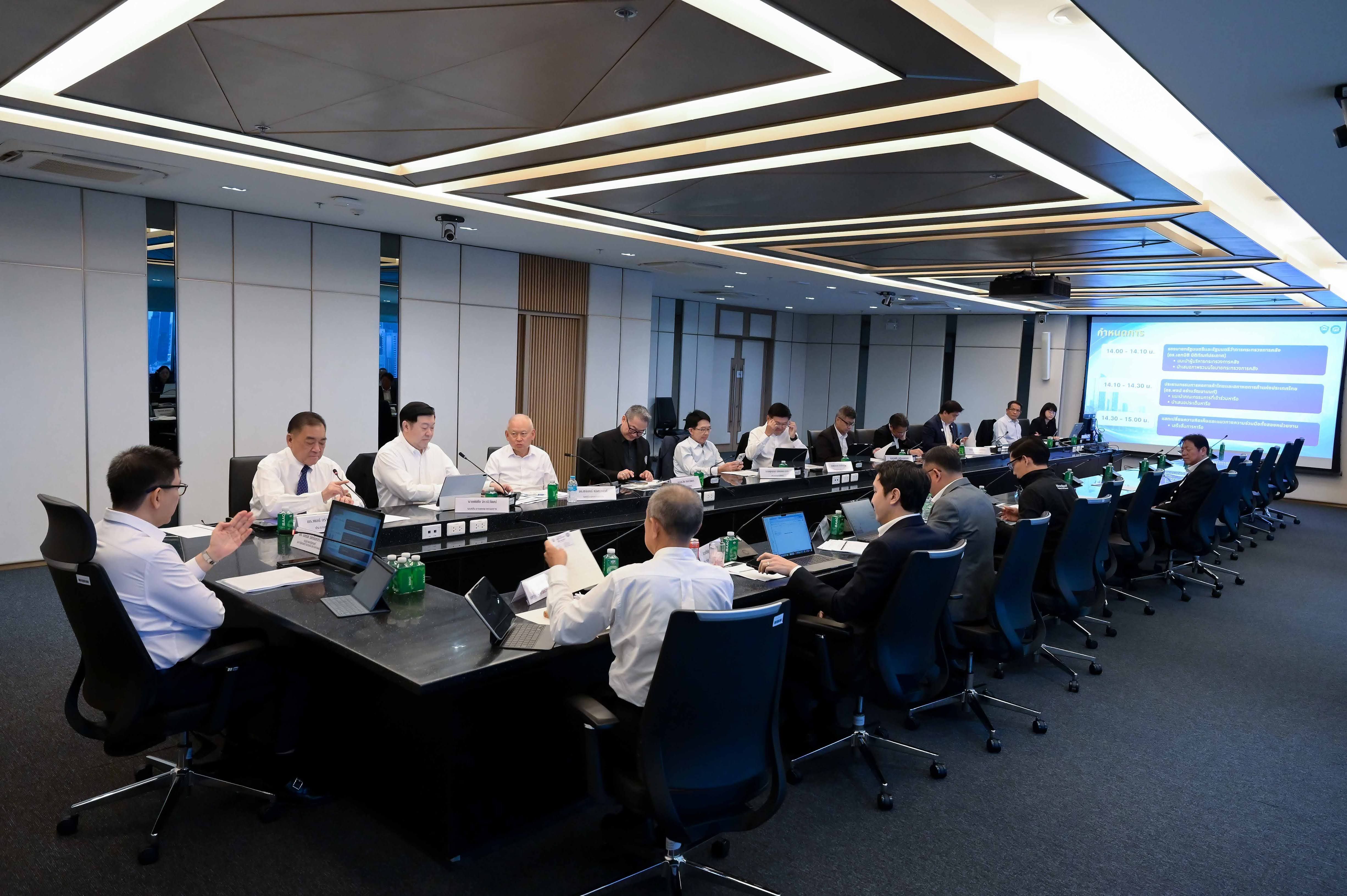 Professionals gathered around a long conference table in a modern meeting room with a projector.