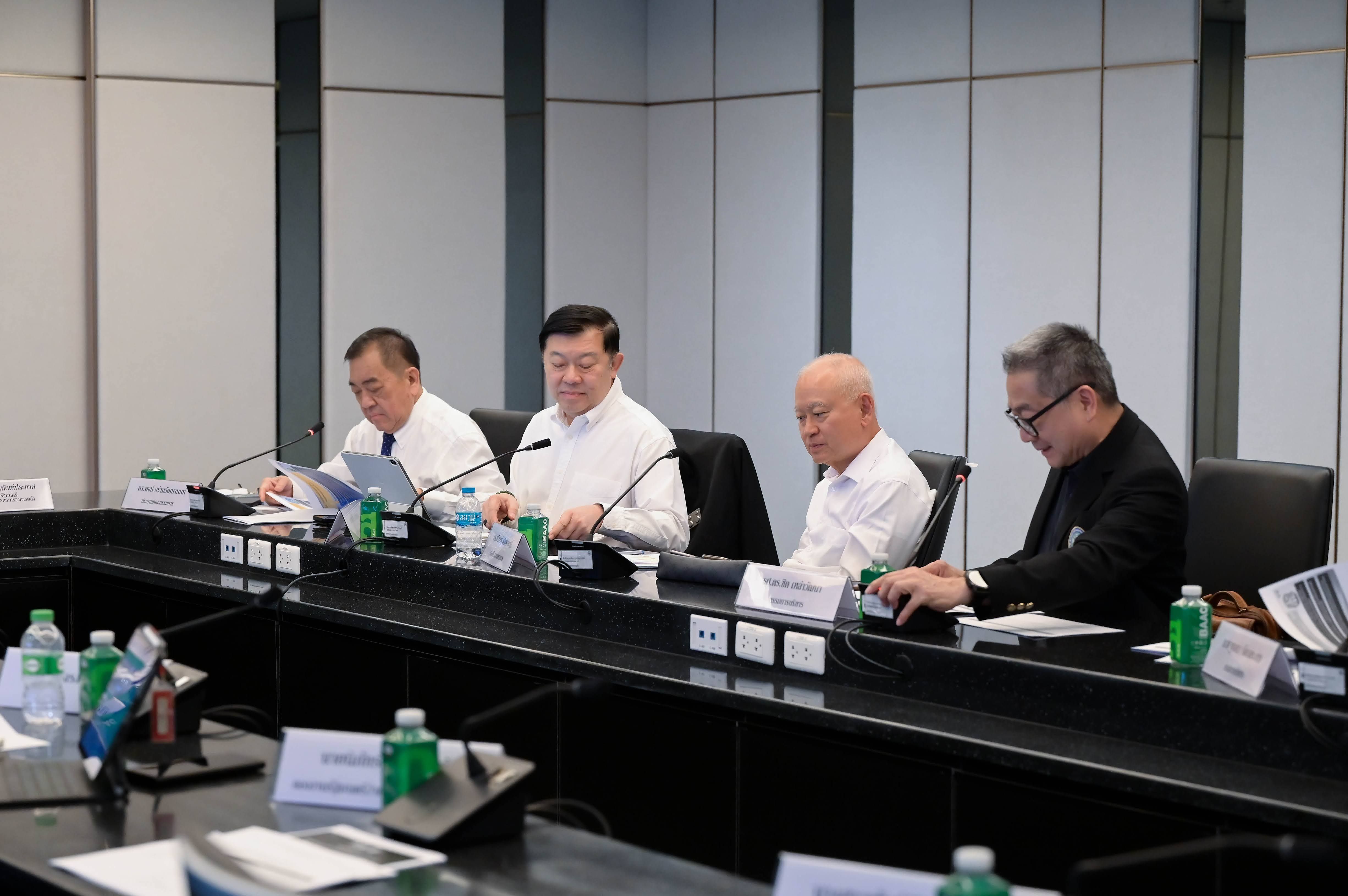Four men in business attire attending a meeting at a large conference table.
