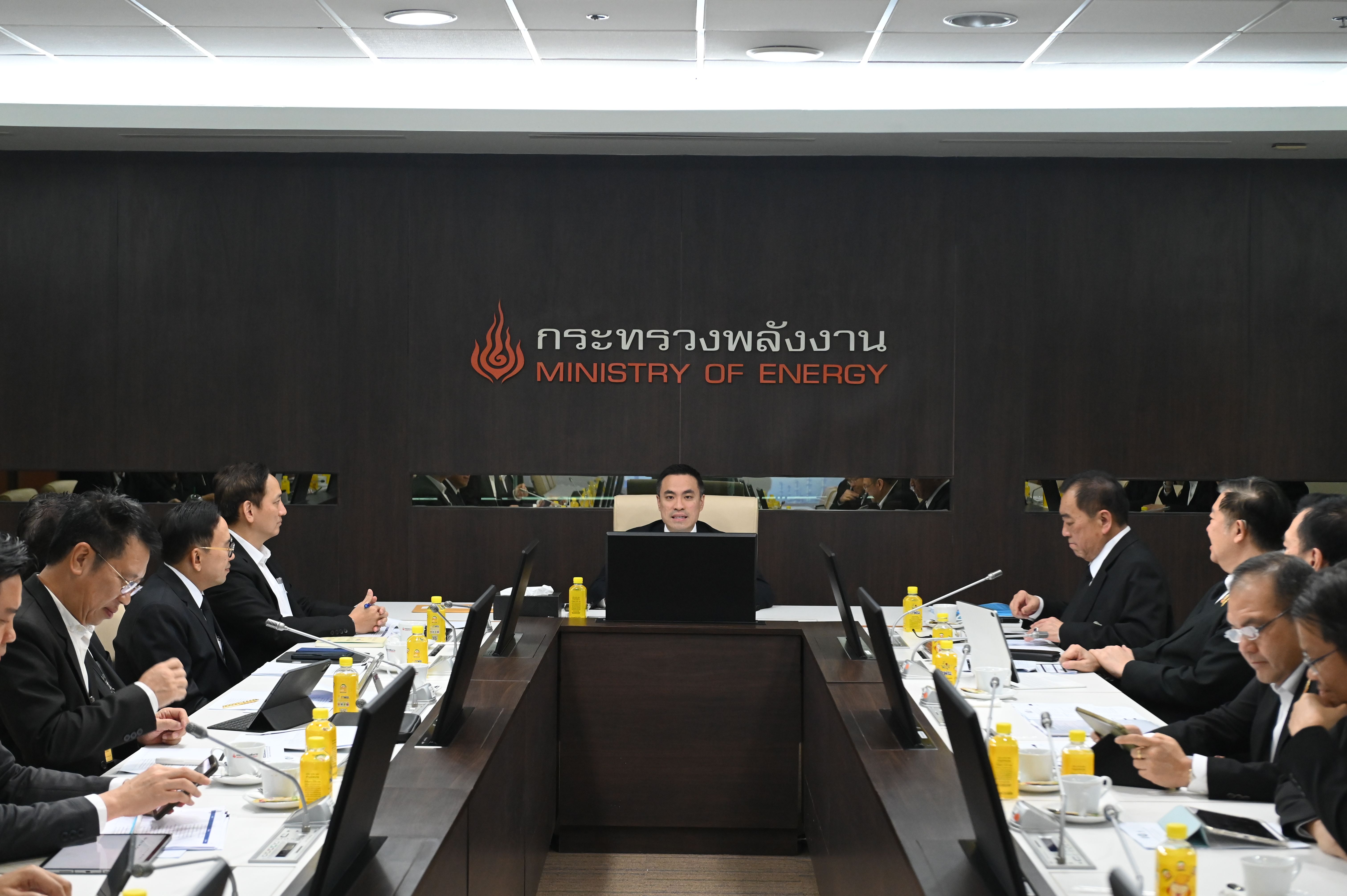 Officials meet around a conference table with 'Ministry of Energy' sign in the background.
