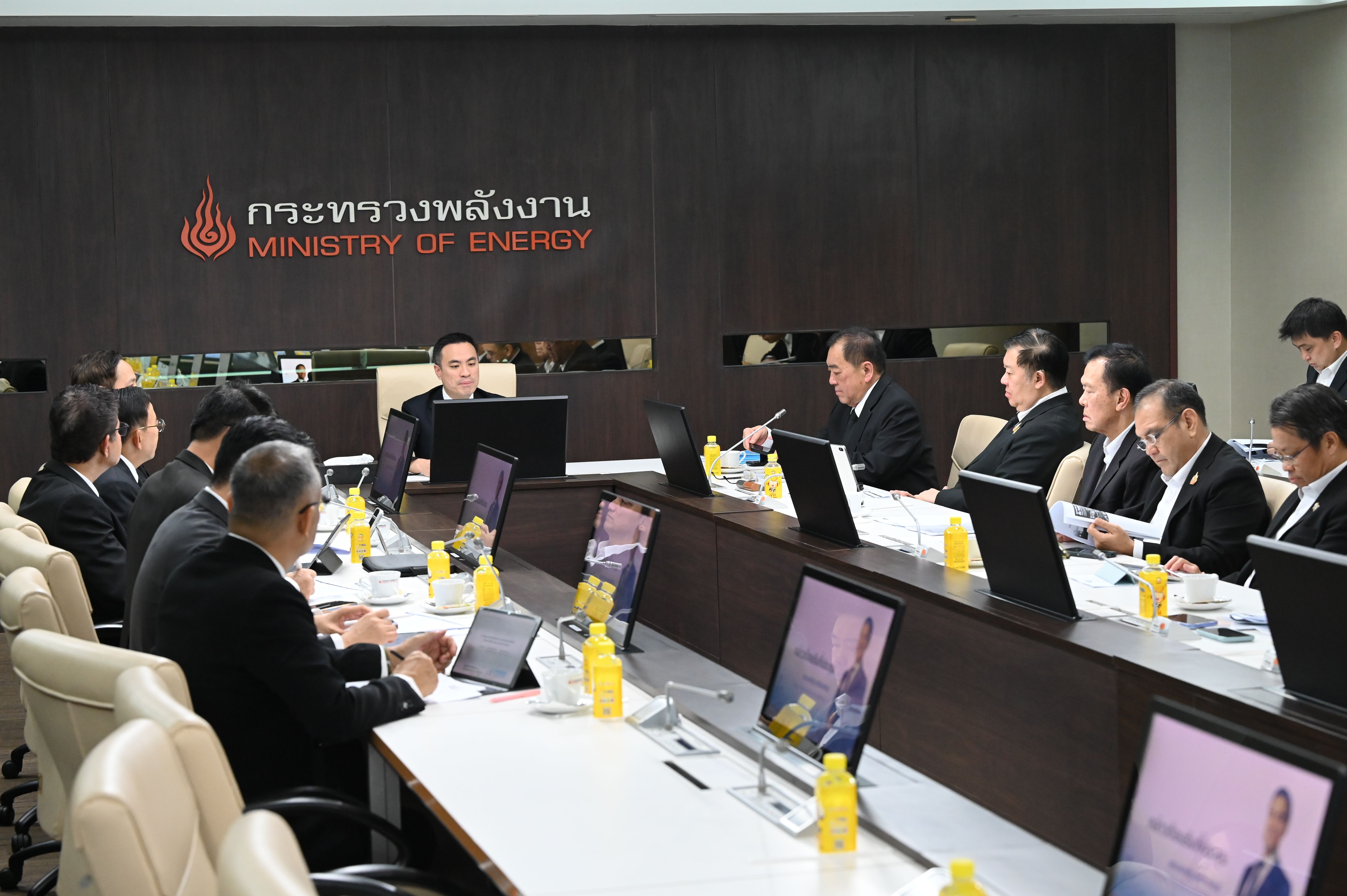 Executives attend a meeting at the Ministry of Energy, with laptops and water on the table.