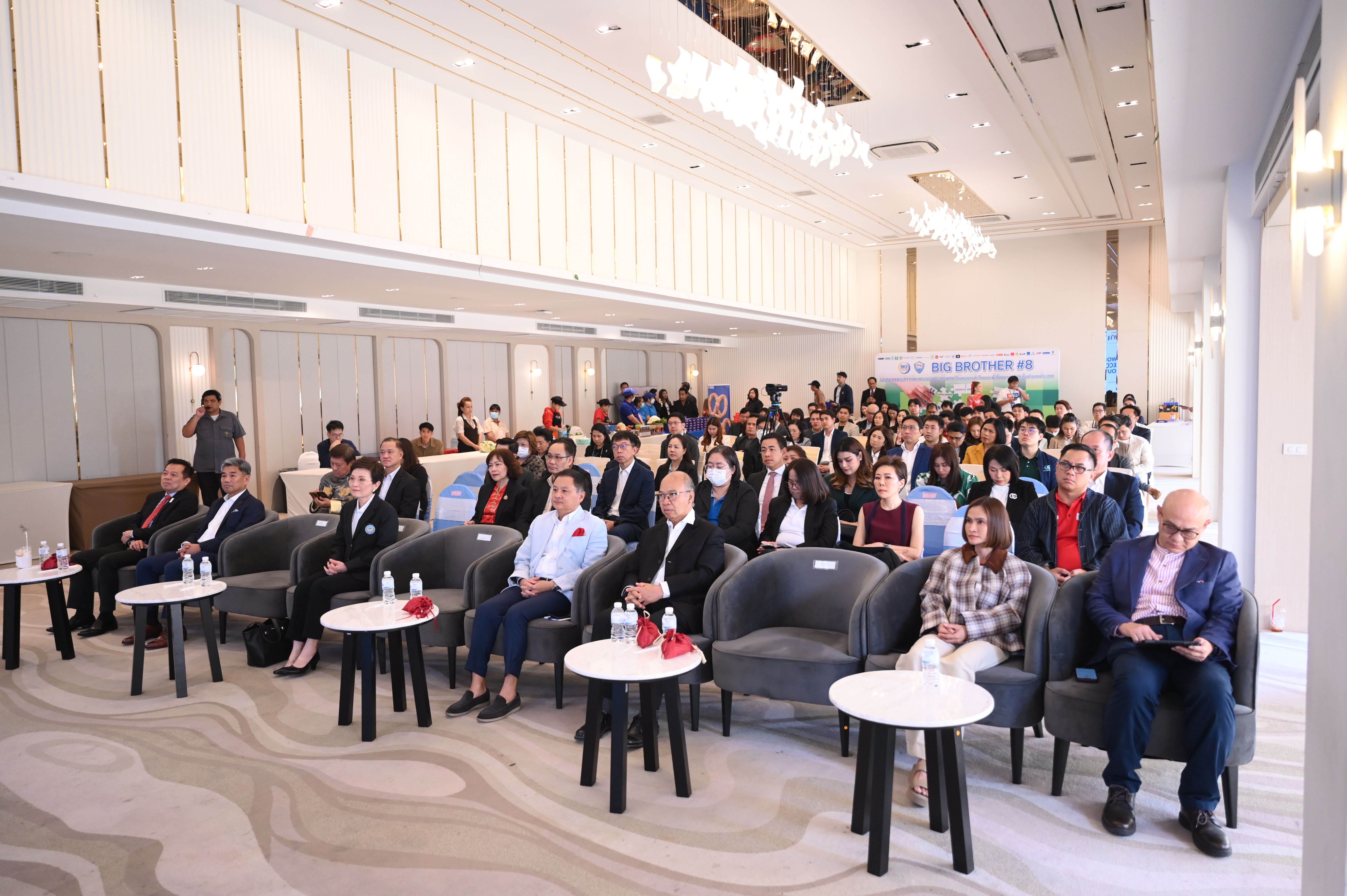 Audience members seated in a brightly lit conference hall during a professional event.