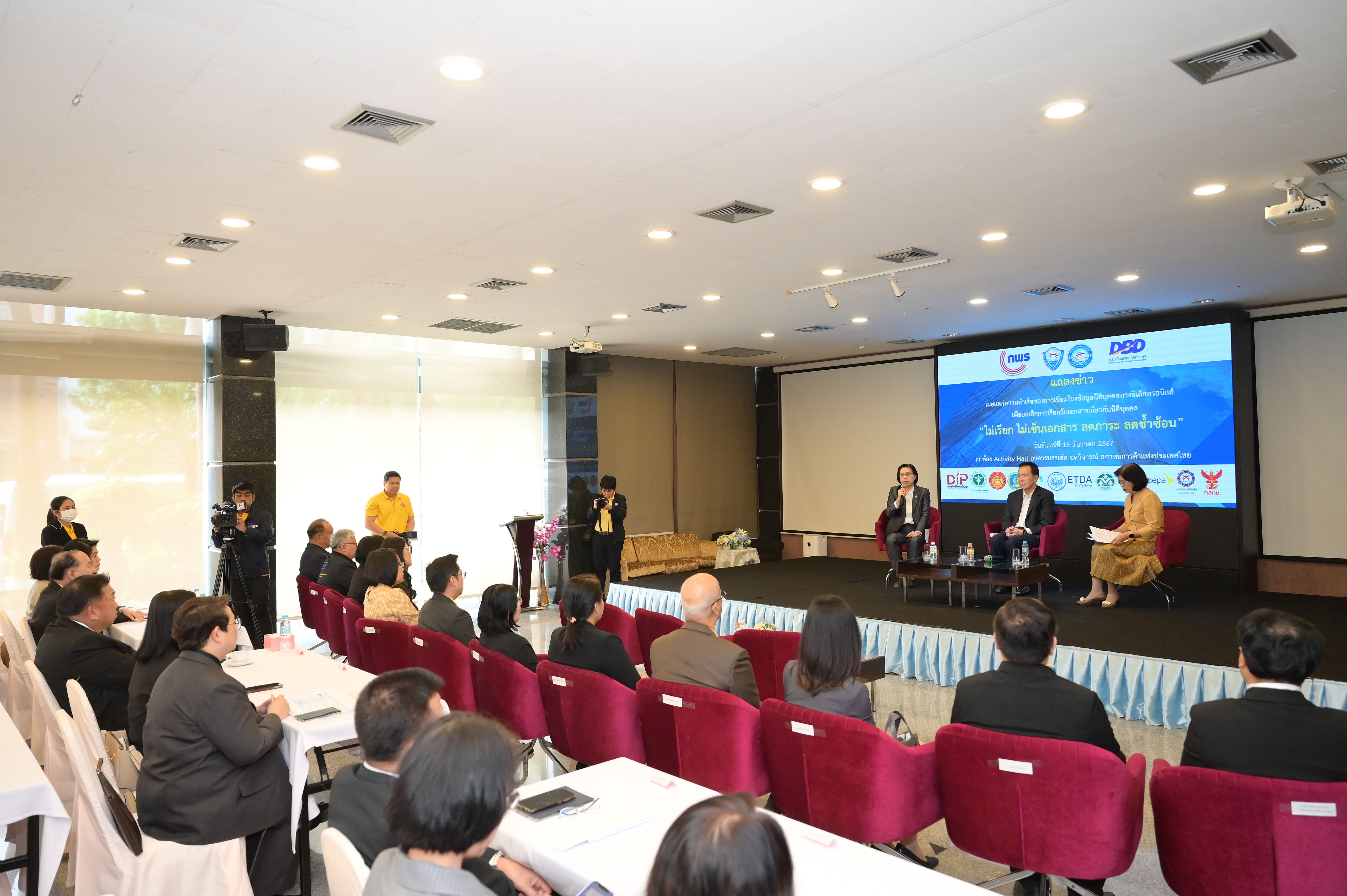 Panel discussion with three speakers on stage addressing an audience at a conference.