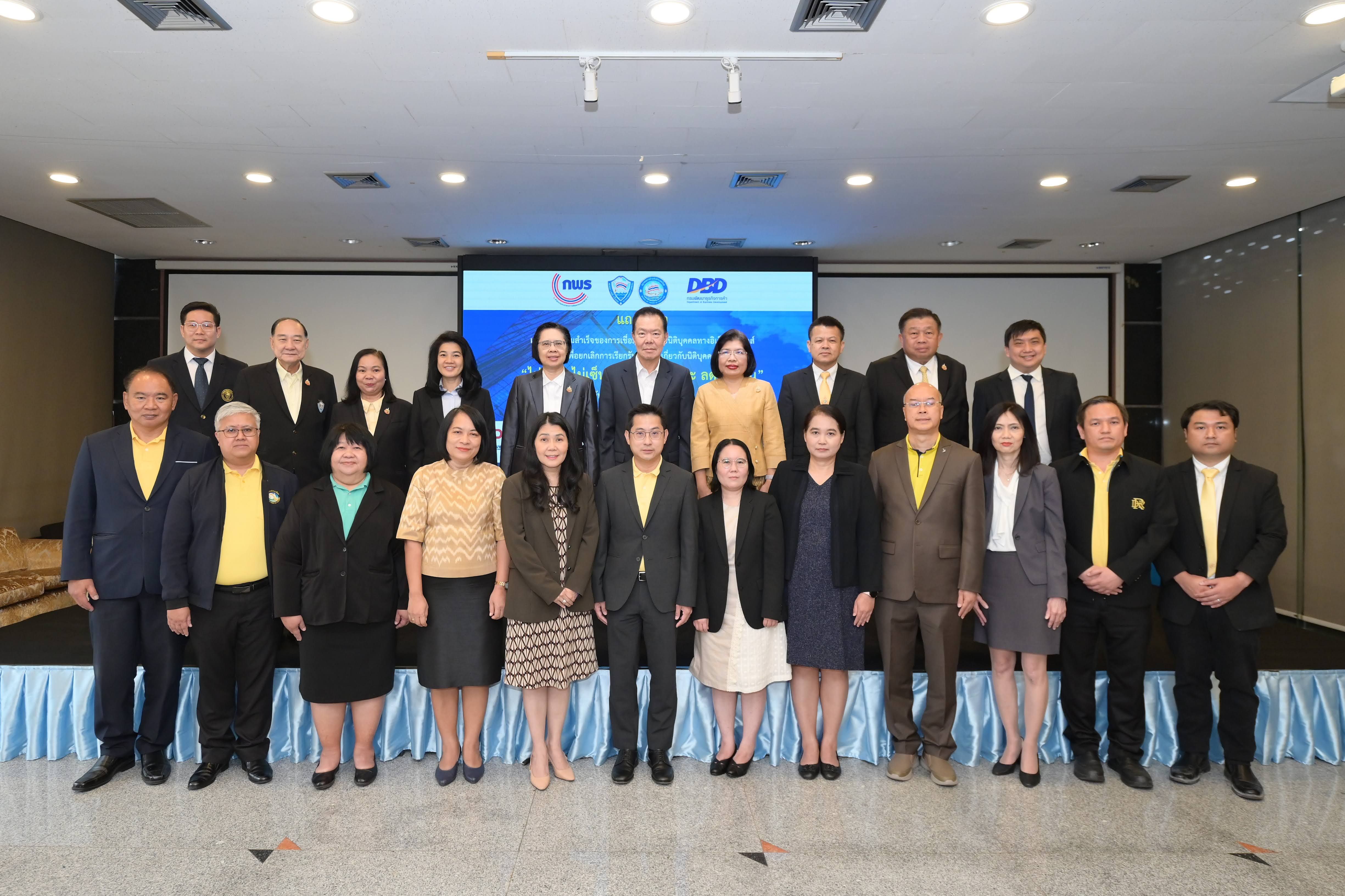 A large group of 23 professionals in formal business attire posing for a photo indoors.