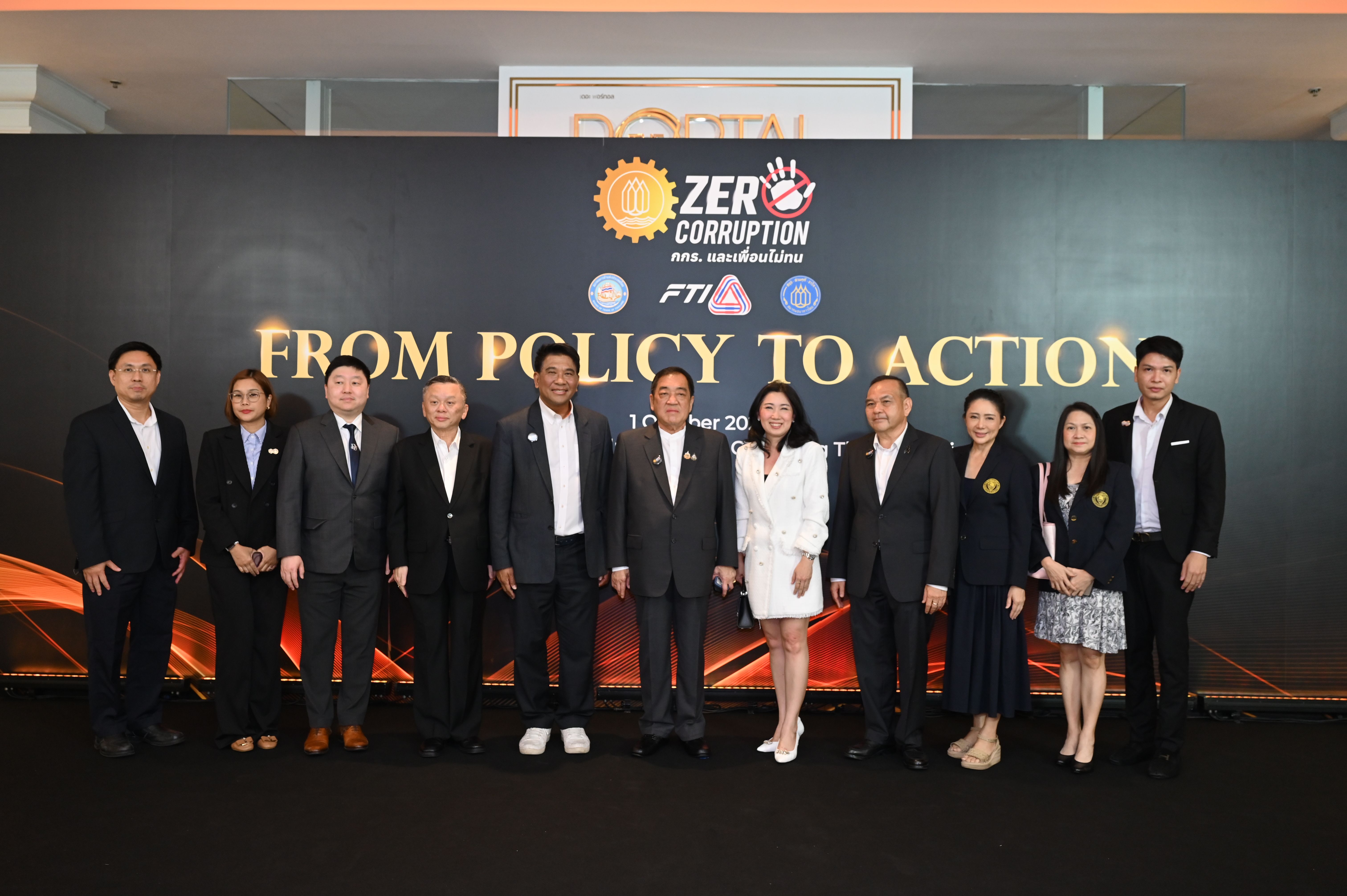 Group of business professionals posing at an event with a "FROM POLICY TO ACTION" banner.
