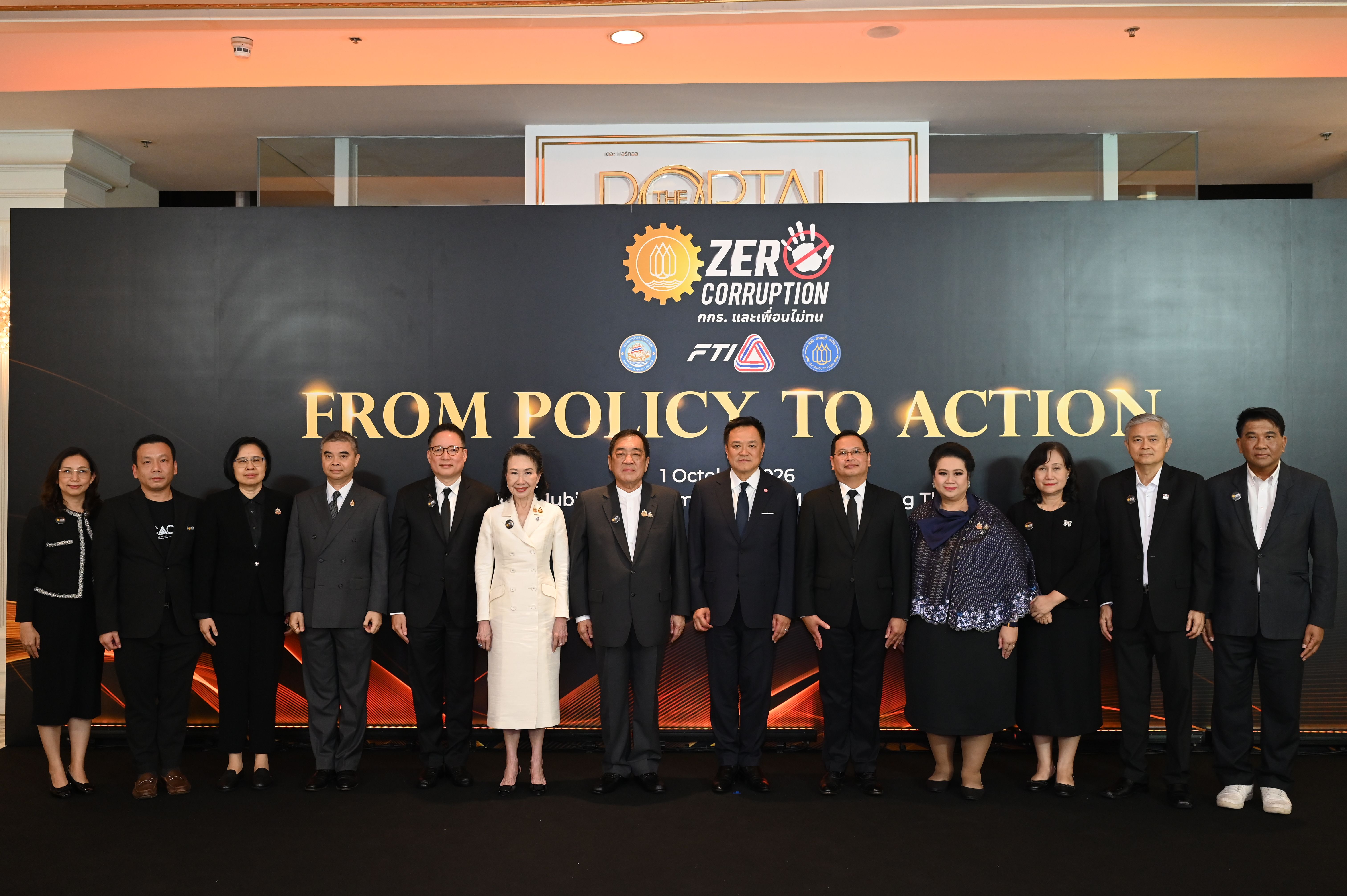 Officials pose in front of a 'FROM POLICY TO ACTION' banner for an anti-corruption event.