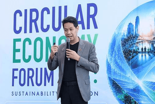 Man speaking into a microphone at the 'Circular Economy Forum' event.
