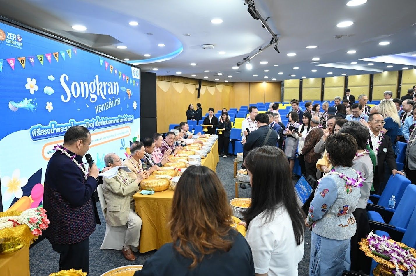 A wide view of a crowded room during a Songkran event with many attendees.
