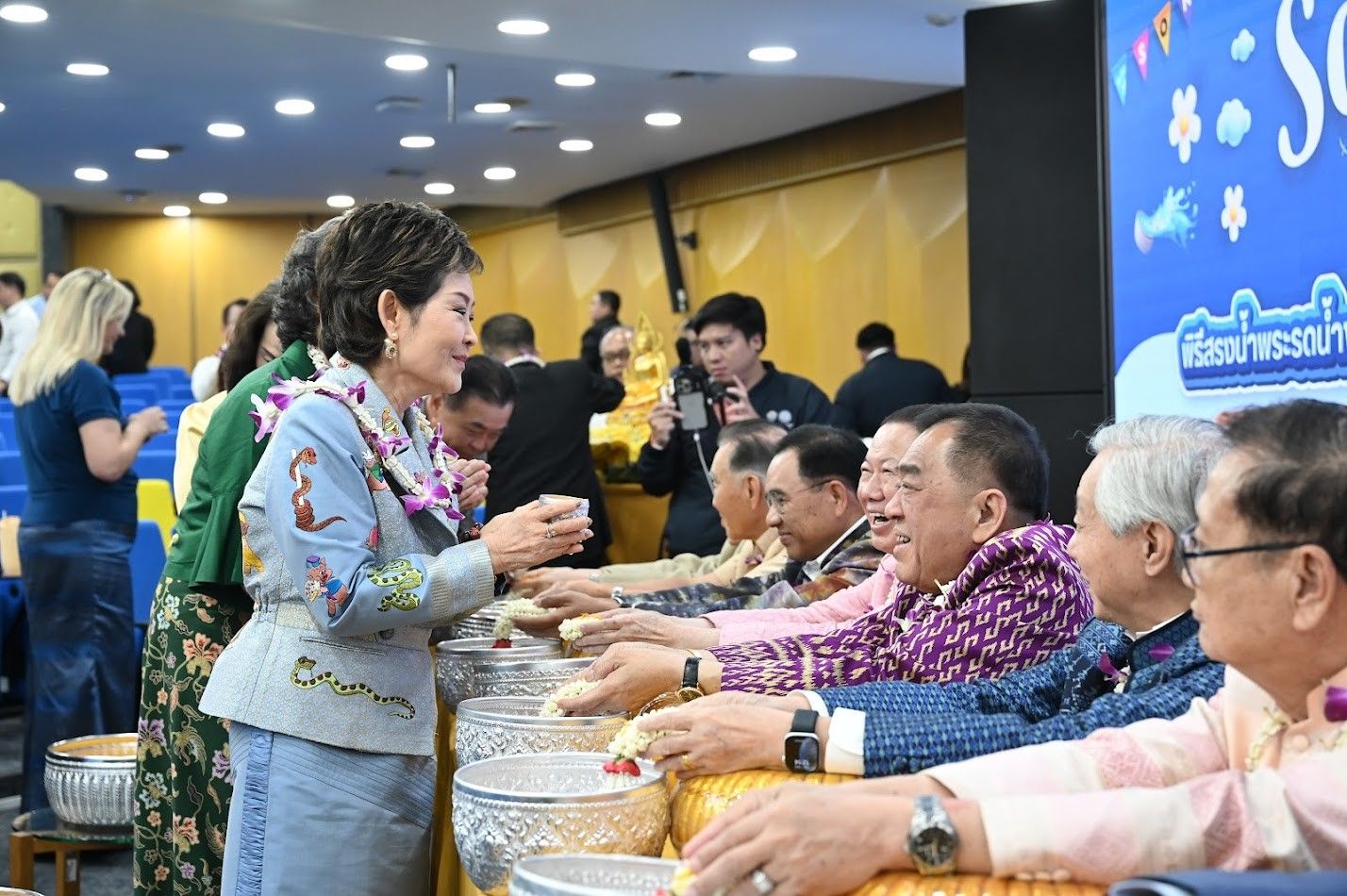 A woman pours water over the hands of an elder during a Songkran tradition.