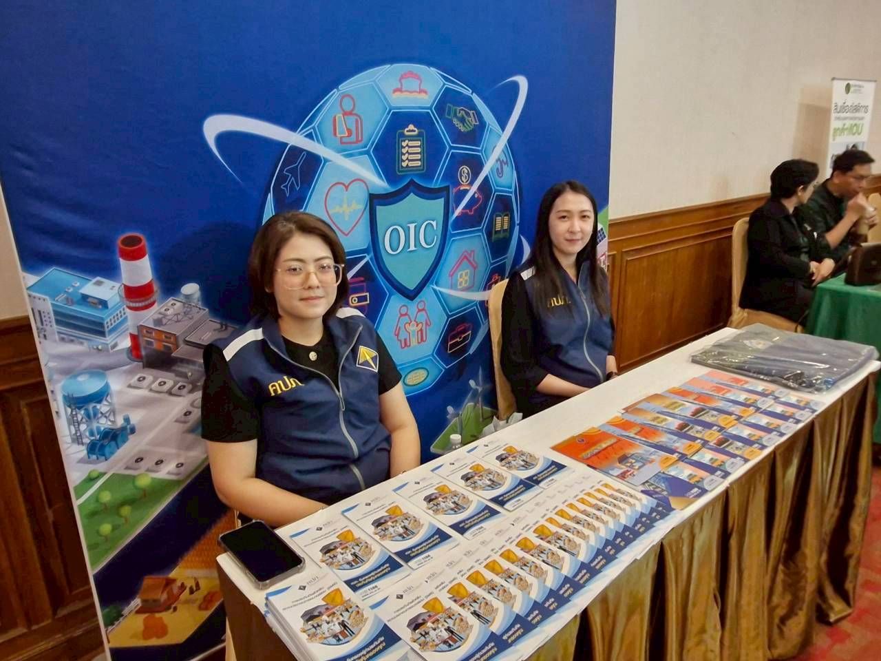 Two women at a DIC booth with promotional materials and a blue banner.